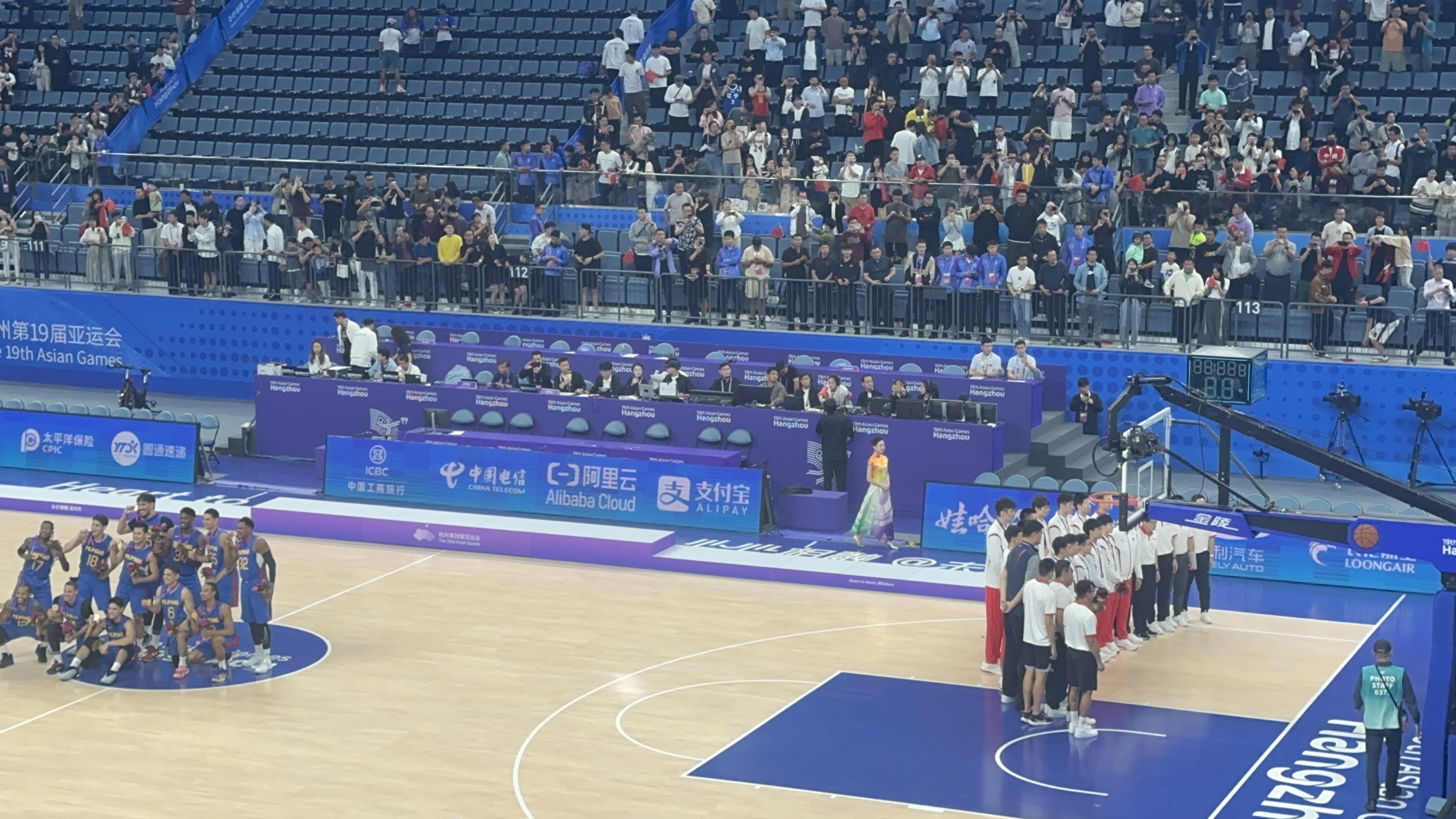 杭州亚运会男篮颁奖结束 中国男篮在球场底线边合影